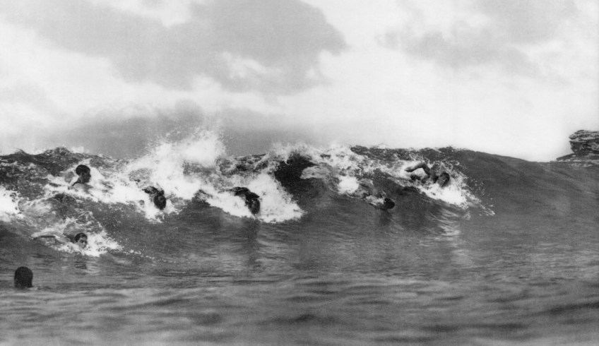 Frank and Albert "Bung" Coulson (both with heads down, left of centre), James Burke (far right), Victor Coppleson and others. South Bondi, ca. 1910. Photographer: Mortimer C. "Crit" Stevenson.